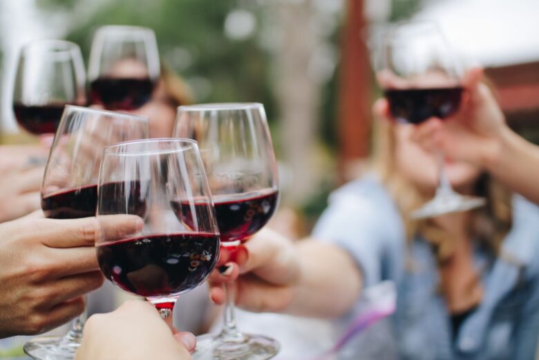 Calici di vino rosso umbro sollevati per un brindisi durante una visita guidata in una cantina locale