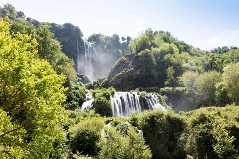 Il maestoso triplo salto d'acqua della Cascata delle Marmore immerso nella fitta vegetazione del parco naturale