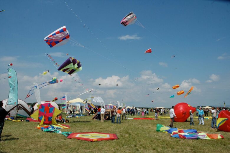 Centinaia di aquiloni colorati e mongolfiere in volo sopra il Lago Trasimeno durante l'evento Coloriamo i Cieli