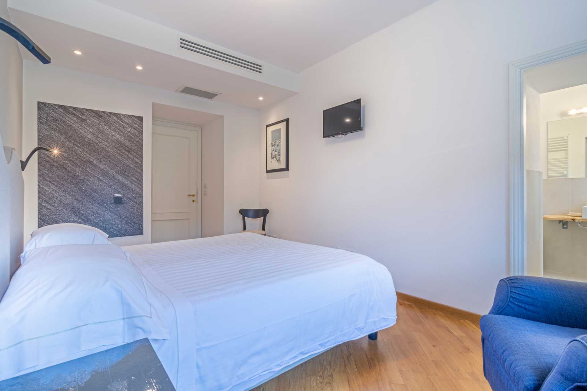 Panoramica di una camera standard con letto matrimoniale, finiture in legno e impianto di climatizzazione dell'Agriturismo ai Prati Perugia